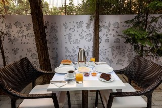 gallery galaxias hotel offers greek breakfast in a cozy outdoor environment surrounded by a garden